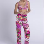 Brunette woman looking down at the ground whilst wearing the Lise Charmel Evonlee de Fleurs Silk Loungewear Trousers with matching Bra