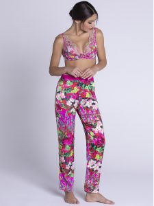 Brunette woman looking down at the ground whilst wearing the Lise Charmel Evonlee de Fleurs Silk Loungewear Trousers with matching Bra