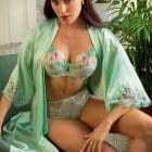 Brunette woman wearing the Lise Charmel Amour Nymphea Robe in jade green over a luxury lingerie set