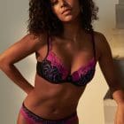 Model wearing Marie Jo Adelade collection bra and brief set in pink, purple and black